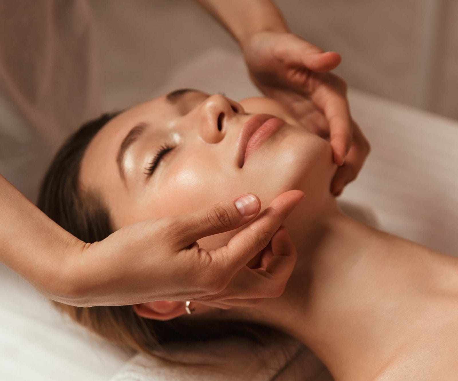 Frau bei entspannender Gesichtsmassage in einem Kosmetikstudium München.