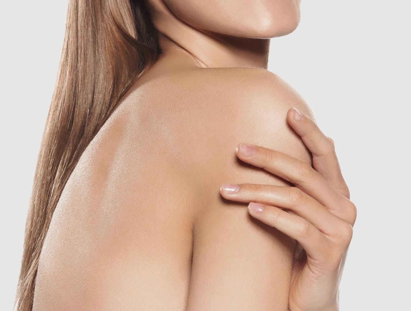 Körperbehandlung Bodylift, Spraytanning München. Frau Streicht mit ihre Hand über ihren Arm und fühlt sch wohl in ihrem Körper